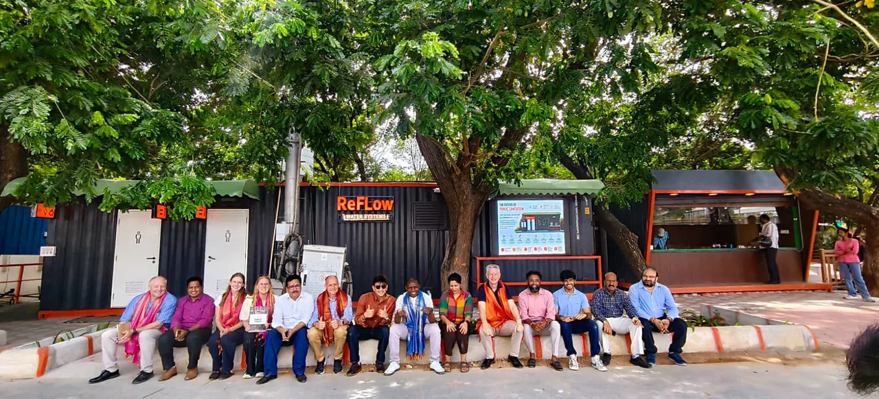 Visitors seated with the LooCafe team outside a ReFlow unit